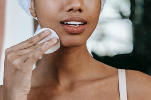 Woman applying skin care on her face