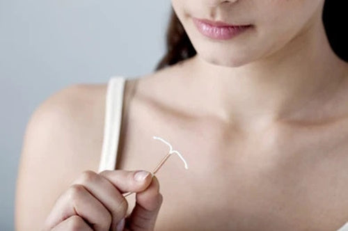 Woman holding a copper IUD