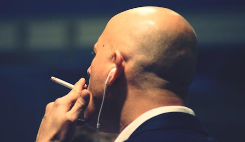 Bald guy smoking cigarette
