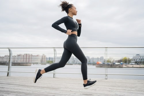 A female runner is running fitness training with tight clothes