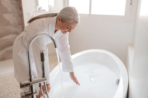 Woman preparing bleach bath at home