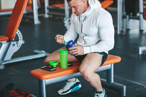 Muscular guy preparing whey protein shake