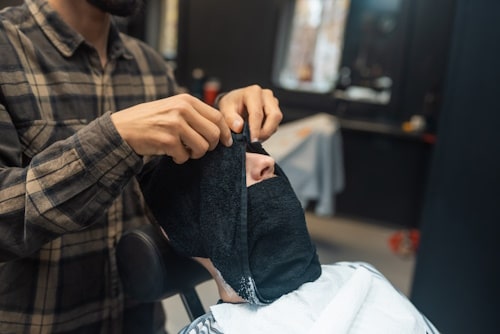 Man getting a hot compress in a barber shop