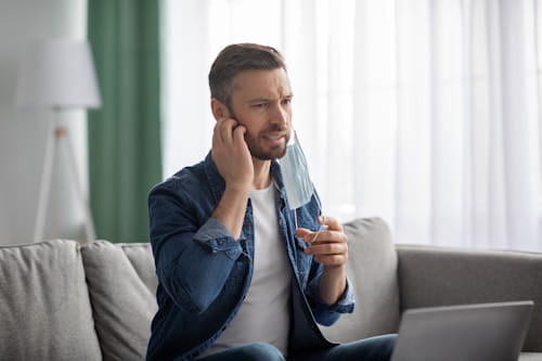 Man scratching his face irritably