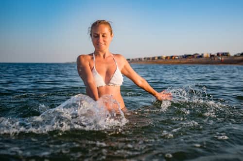 Woman in bikini playing with ocean water