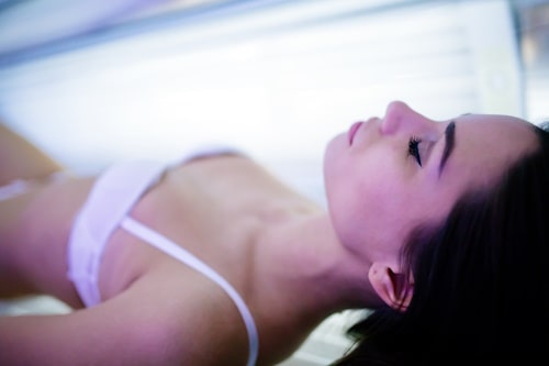 Woman lying on tanning bed