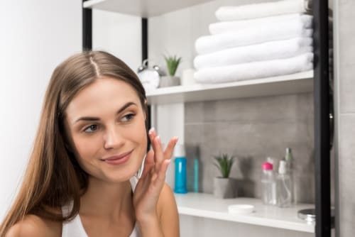 Young woman appily touching her face