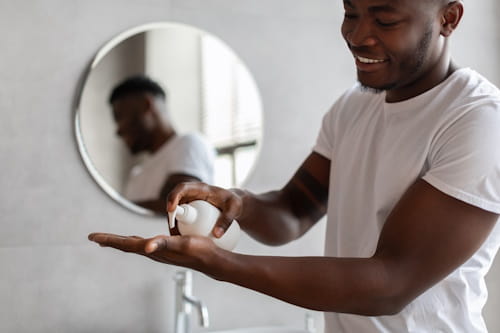 African American man using beard oil