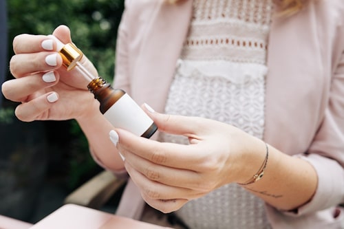 Woman holding a bottle dropper of a salicylic acid