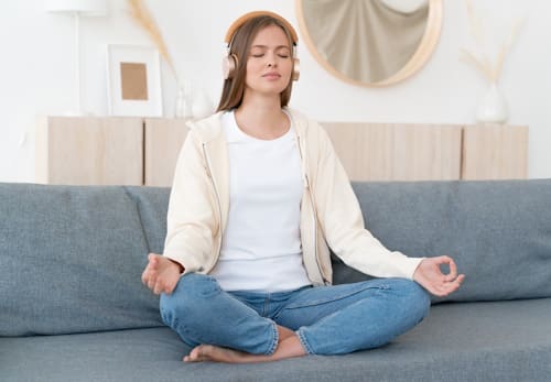 Young woman meditating while listening to music