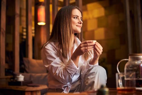 Woman drinking tea happily