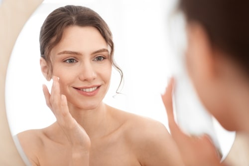 Woman putting moisturizer on her face