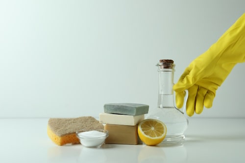 Person taking vinegar from natural cleaning agents