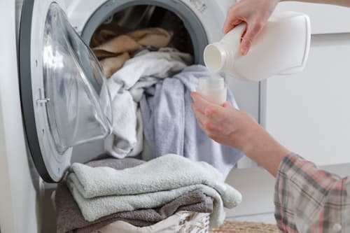 Person washing laundry using detergent