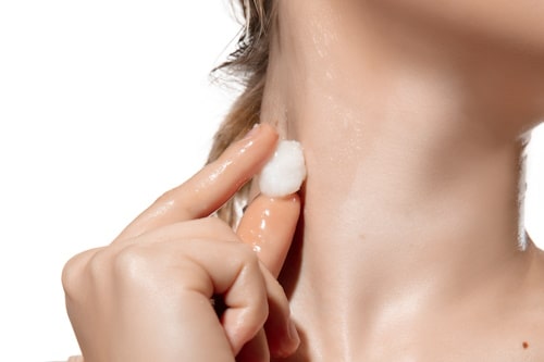 Woman rubbing neck with milk ice
