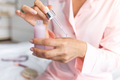 Close up of woman holding bottle of lactic acid serum