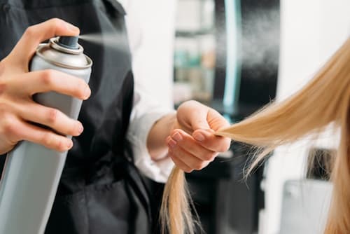 Hairspray being used on woman in salon