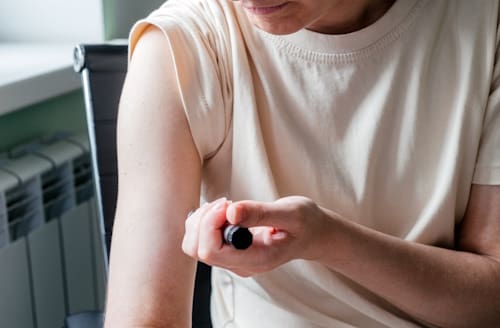 Young woman injecting insulin to her arm