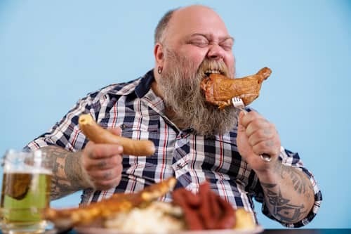 Man eating many greasy foods