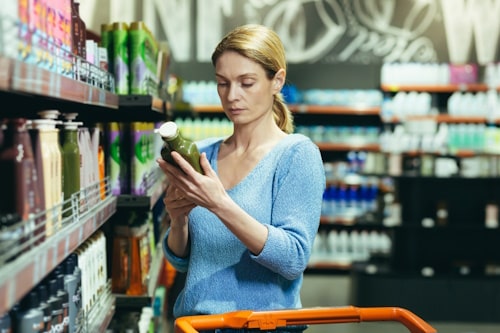 Female chooses and examines product on the supermarket 