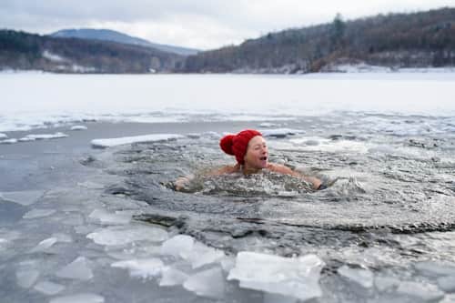 Person taking a dip in an icy lake