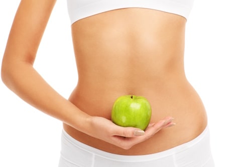 Woman holding an apple near her stomach