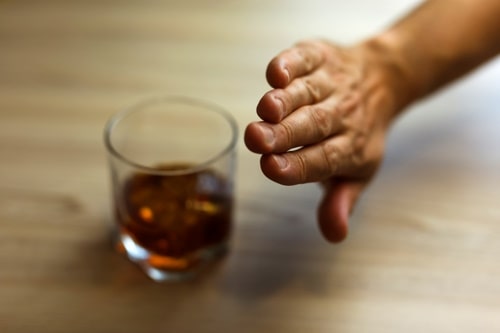 Hands lock chain a glass of whiskey to stop drinking