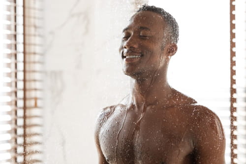 Man taking cold shower after gym