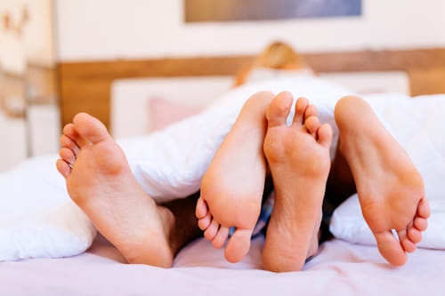 Image of two pairs of feet implying sexual intercourse