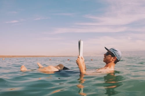 Man reading newspaper while floating on the dead sea