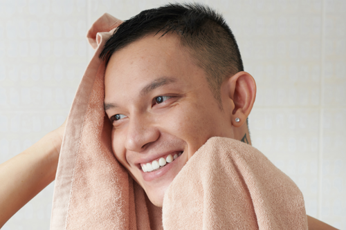 Man using towel to cold compress ears