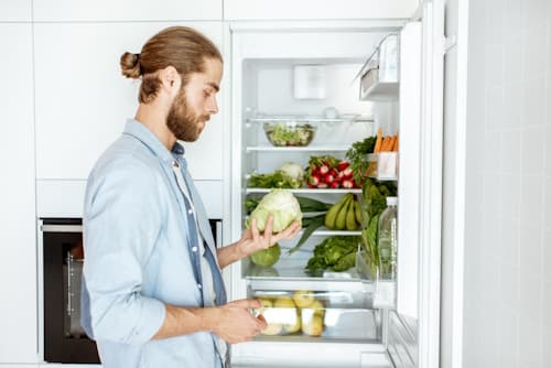 Man getting vegetables from refrigirator