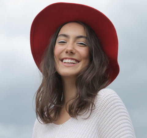A woman smiles in a red hat