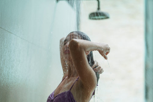 A woman taking a cold shower