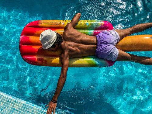 A man sun bathing while in a pool