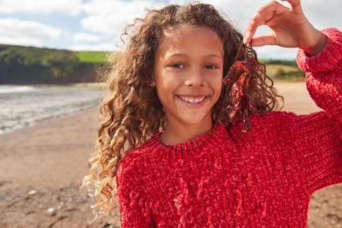 Portrait of smiling girl holding sea moss