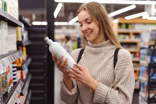 Woman reading hair spray packaging at mall