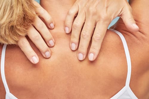 Woman feeling her nape and back for any acne
