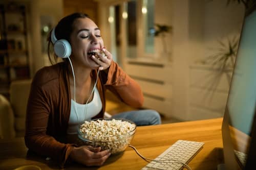 Woman watching a movie while eating popcorn