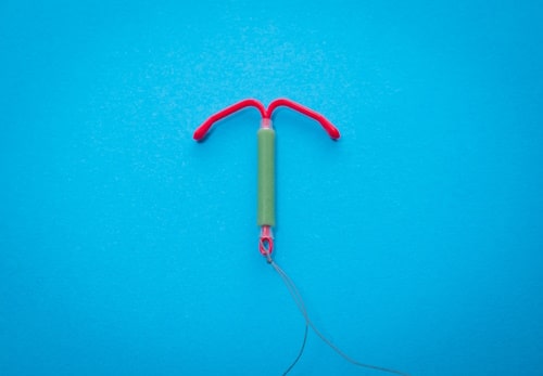 IUD on a table with blue background