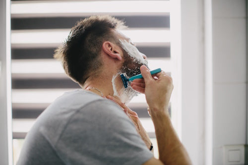 Man shaving in front of a mirror