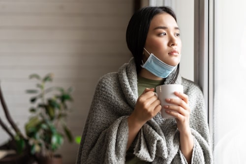 Sick asian girl in medical face mask standing 