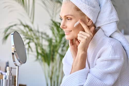 Senior woman applying face cream