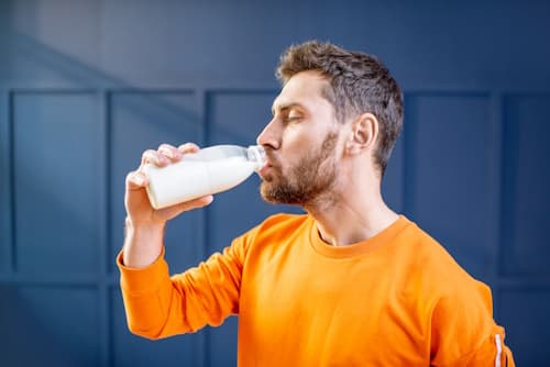 Man drinking a bottle of milk