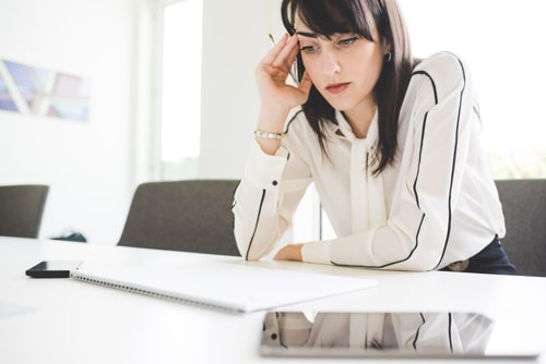 Stressed young businesswoman at office desk 