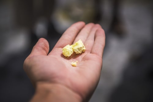 Person holding piece of sulfur with bare hands