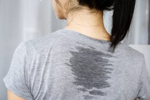 Woman with sweaty back with grey shirt
