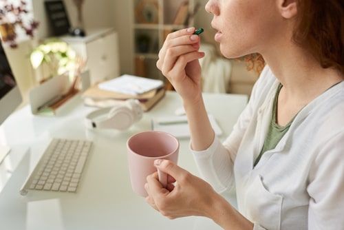 Woman taking protein supplement pills