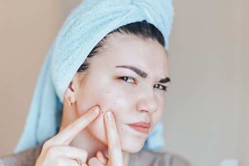 Woman picking on her pimple