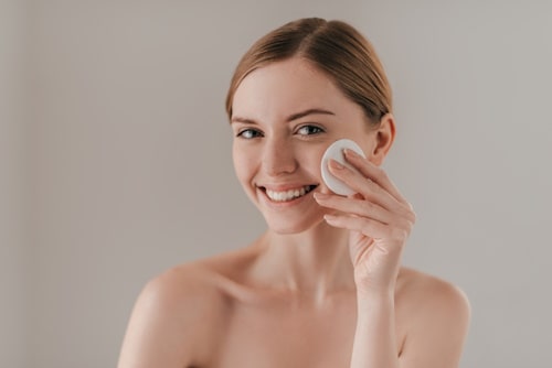 Applying clear pore serum with a cotton pad